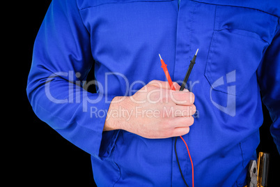 Composite image of electrician holding multimeter