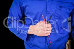 Composite image of electrician holding multimeter
