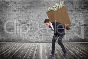 Composite image of businessman carrying something heavy with his