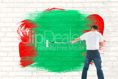 Composite image of man using paint roller on white background