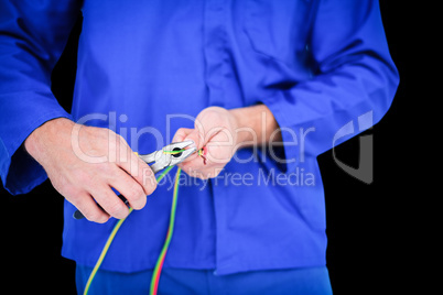 Composite image of electrician cutting wire with pliers