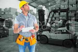 Composite image of manual worker looking away while writing on c