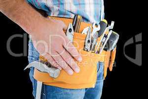 Composite image of midsection of handyman wearing tool belt