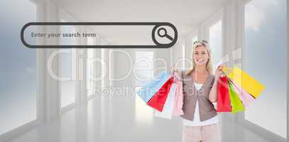 Composite image of happy blonde holding shopping bags