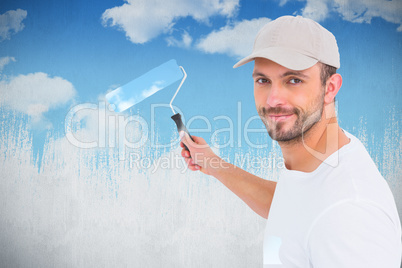 Composite image of handyman holding paint roller