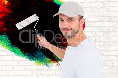 Composite image of handyman holding paint roller