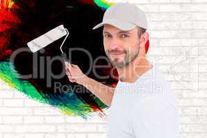 Composite image of handyman holding paint roller
