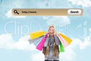 Composite image of blonde in winter clothes holding shopping bag