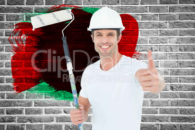 Composite image of man holding paint roller while gesturing thumbs up