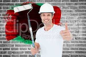 Composite image of man holding paint roller while gesturing thumbs up