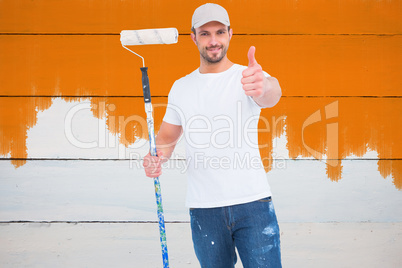 Composite image of handyman holding paint roller