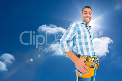 Composite image of portrait of smiling handyman wearing tool bel