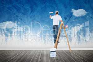 Composite image of man on ladder painting with roller