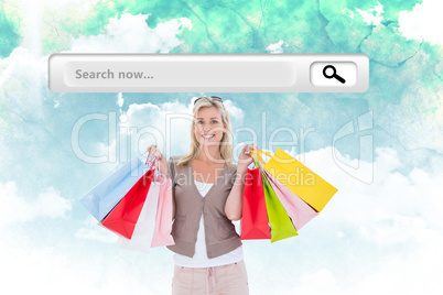 Composite image of happy blonde holding shopping bags