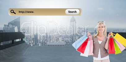 Composite image of happy blonde holding shopping bags