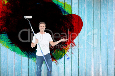 Composite image of man gesturing while holding paint roller
