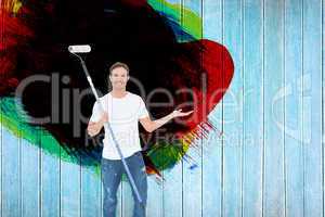 Composite image of man gesturing while holding paint roller