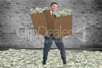 Composite image of businessman carrying bags of dollars