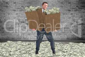 Composite image of businessman carrying bags of dollars