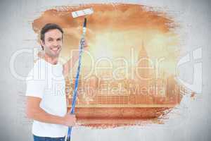 Composite image of happy man using paint roller