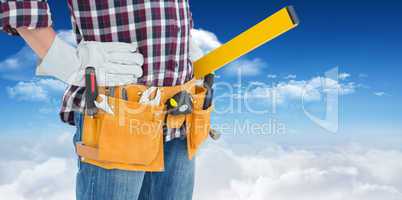 Composite image of repairman wearing tool belt while standing wi