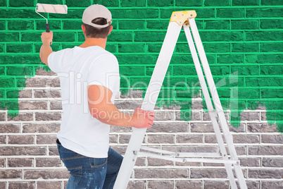 Composite image of handyman climbing ladder while using paint ro