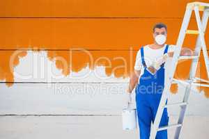 Composite image of handyman with paintbrush and can leaning on l