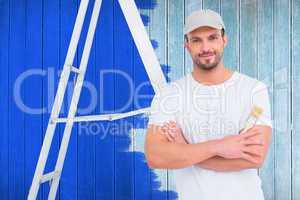 Composite image of handyman with paintbrush and ladder