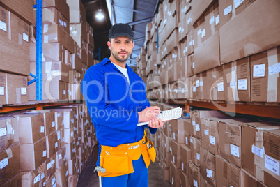 Composite image of handyman in blue overall writing on clipboard