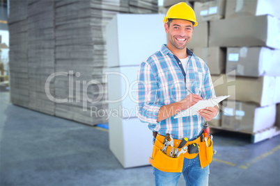 Composite image of portrait of smiling handyman writing on clipb
