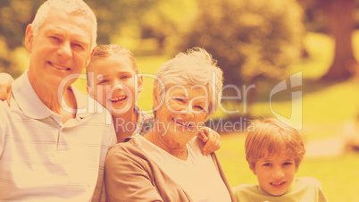 Smiling senior couple and grandchildren at park