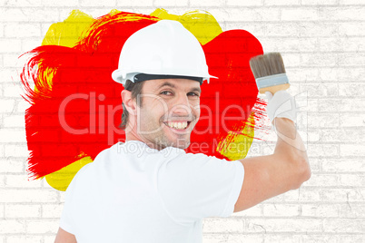 Composite image of portrait of happy man using paintbrush