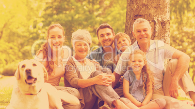 Extended family with their pet dog sitting at park