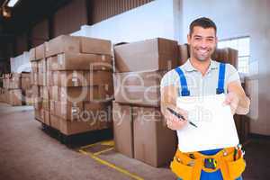 Composite image of smiling handyman giving clipboard for signatu