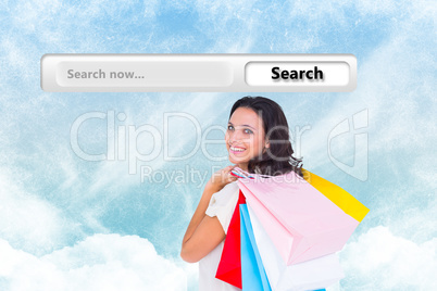 Composite image of pretty brunette with shopping bags