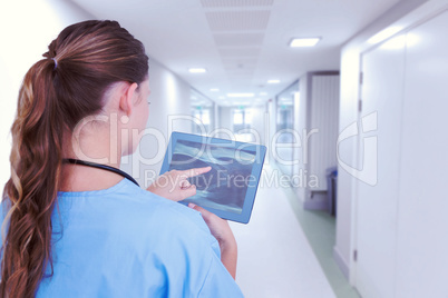 Composite image of doctor looking at xray on tablet