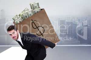 Composite image of businessman carrying bag of dollars