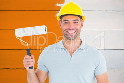 Composite image of portrait of manual worker holding paint rolle