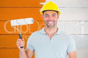 Composite image of portrait of manual worker holding paint rolle