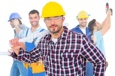 Composite image of handyman holding rolled up blueprint