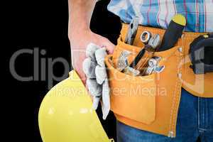 Composite image of manual worker wearing tool belt while holding