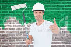 Composite image of man holding paint roller while gesturing thum