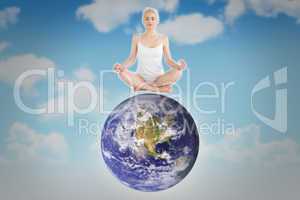 Composite image of toned young woman sitting in lotus pose with