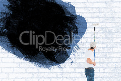 Composite image of man using paint roller on white background