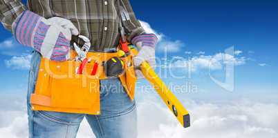Composite image of handyman holding spirit level