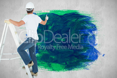 Composite image of man on ladder painting with roller