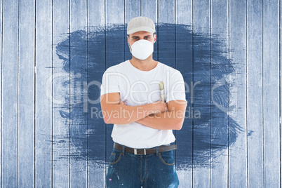 Composite image of man with paintbrush standing arms crossed by ladder