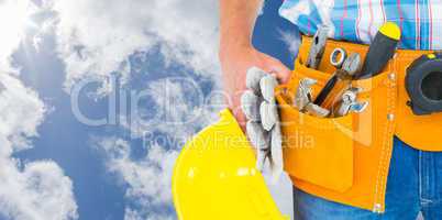 Composite image of manual worker wearing tool belt while holding