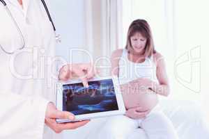 Composite image of doctor looking at xray on tablet