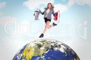 Composite image of festive blonde jumping with shopping bags
